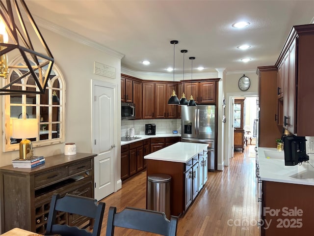 3000 J R Ct, Stanley, NC 28164 - kitchen featuring crown molding, appliances with stainless steel finishes, wood finished floors, tasteful backsplash, and a kitchen island