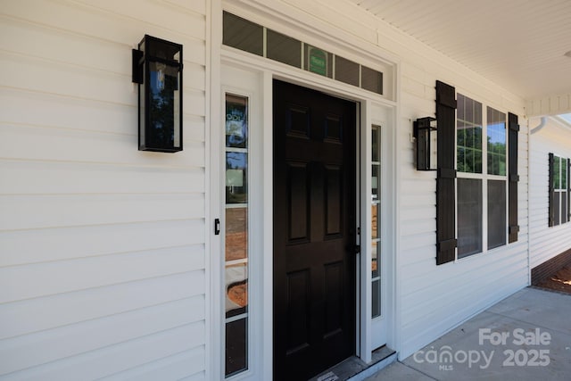 view of exterior entry featuring covered porch
