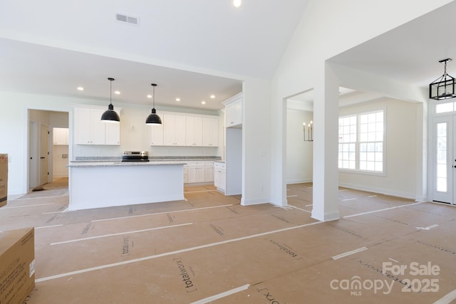 kitchen featuring visible vents, white cabinets, and decorative light fixtures