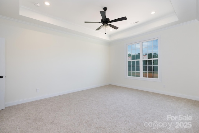 carpeted empty room featuring crown molding, a tray ceiling, and recessed lighting