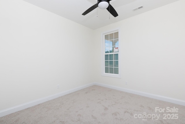 carpeted spare room with ceiling fan, visible vents, and baseboards