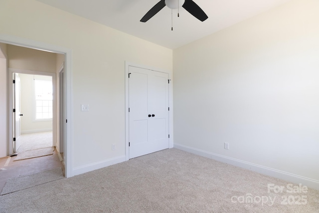 unfurnished bedroom with a closet, baseboards, ceiling fan, and carpet flooring
