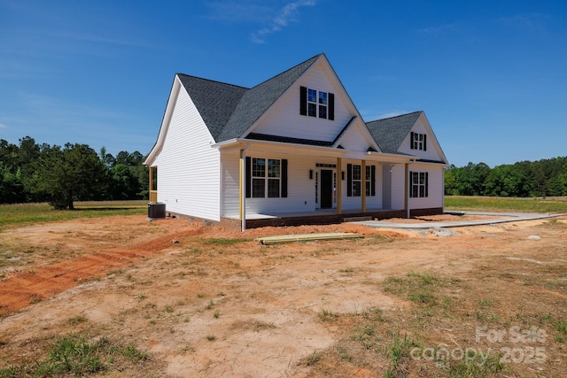 modern farmhouse with a shingled roof, covered porch, and central AC unit