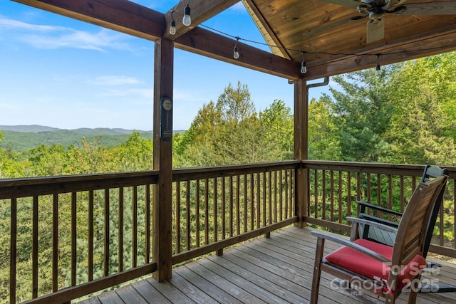 wooden terrace with a ceiling fan and a mountain view
