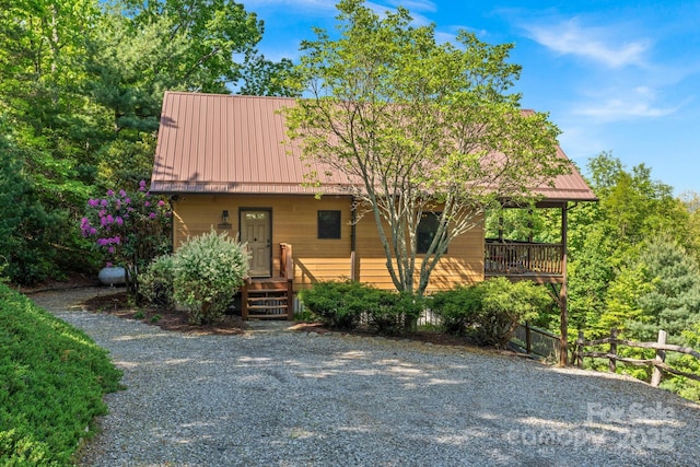 rustic home with fence, a standing seam roof, and metal roof
