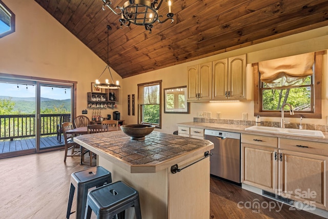 kitchen featuring tile countertops, dishwasher, a sink, a notable chandelier, and light brown cabinets