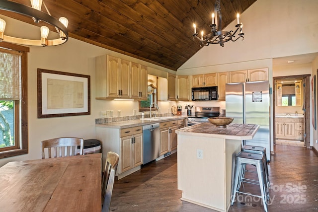kitchen featuring a notable chandelier, appliances with stainless steel finishes, a sink, light brown cabinets, and wooden ceiling
