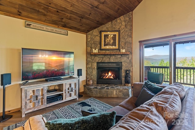 living area featuring wood ceiling, vaulted ceiling, a stone fireplace, and wood finished floors