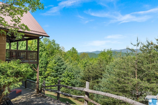 exterior space with a view of trees, a mountain view, and fence