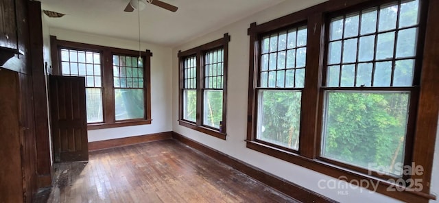 interior space featuring baseboards, dark wood finished floors, and ceiling fan
