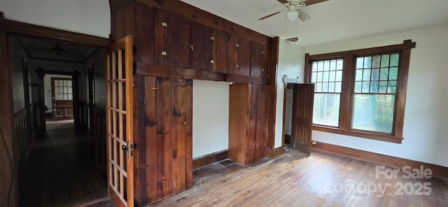 interior space featuring baseboards, ceiling fan, and hardwood / wood-style flooring
