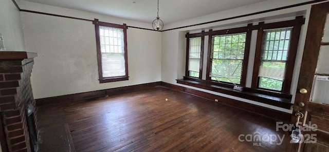 unfurnished dining area featuring a healthy amount of sunlight, baseboards, and wood finished floors
