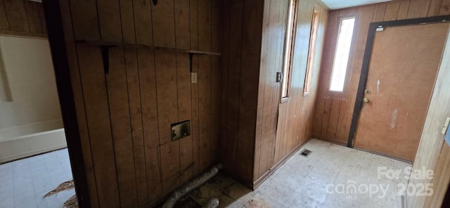 interior space featuring wooden walls, tile patterned floors, and visible vents