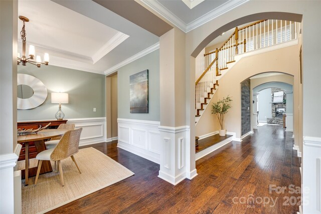 308 Hollister Estates Dr, Waxhaw, NC 28173 - entryway with stairs, wood finished floors, arched walkways, ornamental molding, and a chandelier