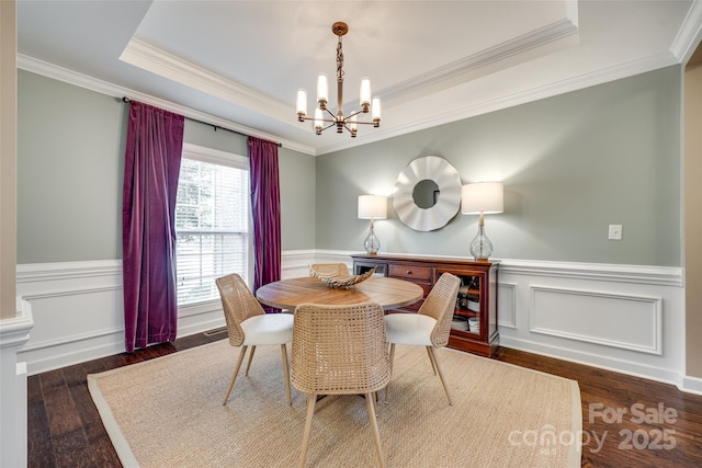 308 Hollister Estates Dr, Waxhaw, NC 28173 - dining area with a chandelier, a raised ceiling, wood finished floors, crown molding, and wainscoting