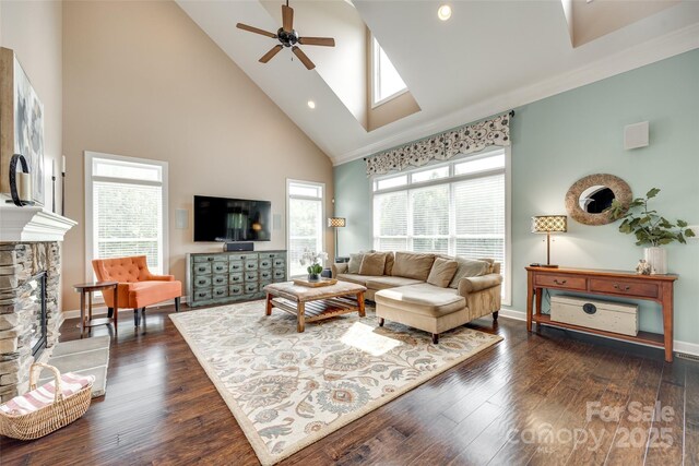 308 Hollister Estates Dr, Waxhaw, NC 28173 - living room with high vaulted ceiling, ceiling fan, a stone fireplace, baseboards, and dark wood finished floors