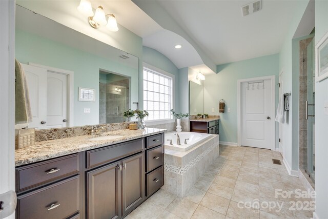 308 Hollister Estates Dr, Waxhaw, NC 28173 - full bathroom featuring a stall shower, two vanities, a bath, tile patterned floors, and lofted ceiling