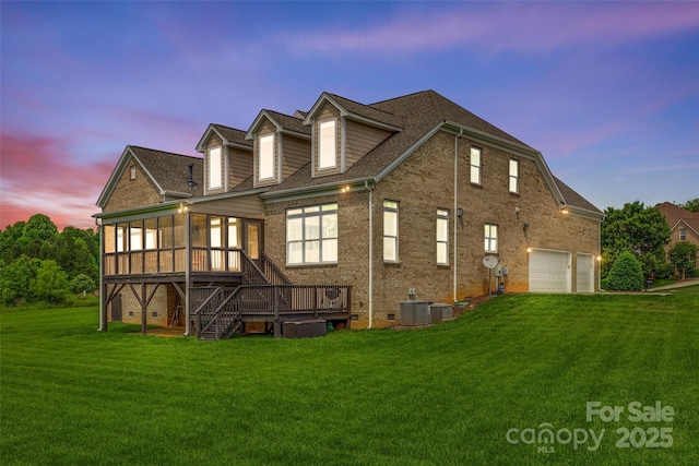 308 Hollister Estates Dr, Waxhaw, NC 28173 - back of house at dusk featuring a sunroom, central air condition unit, a yard, stairway, and brick siding