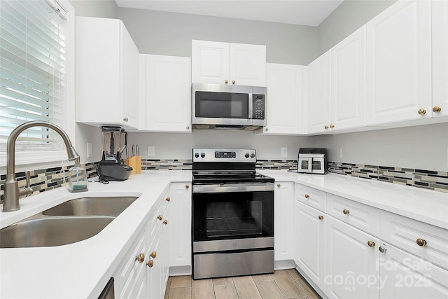 5943 Pisgah Way, Charlotte, NC 28217 - kitchen with white cabinets, stainless steel appliances, a sink, and tasteful backsplash