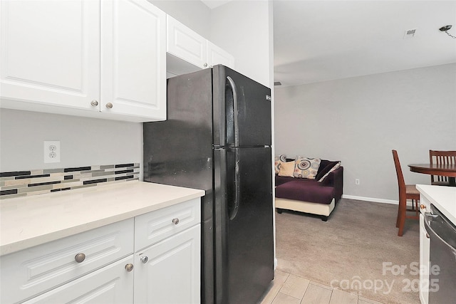 5943 Pisgah Way, Charlotte, NC 28217 - kitchen with stainless steel dishwasher, light countertops, white cabinets, freestanding refrigerator, and light carpet