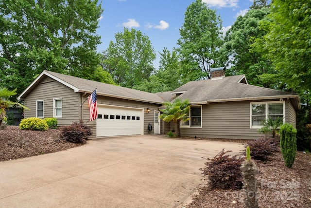 single story home with a garage, a chimney, and concrete driveway