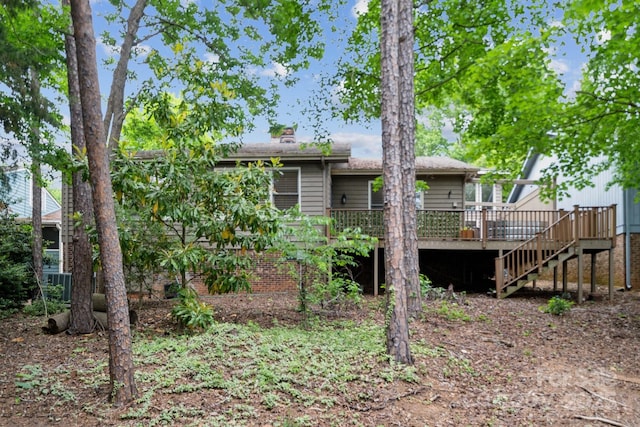 rear view of house featuring stairway and a deck