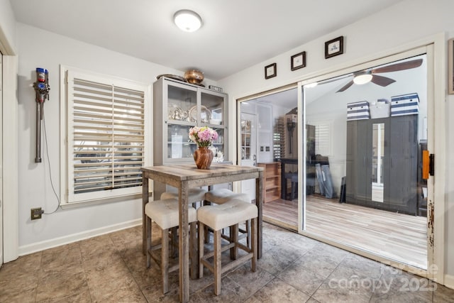 dining area featuring ceiling fan and baseboards