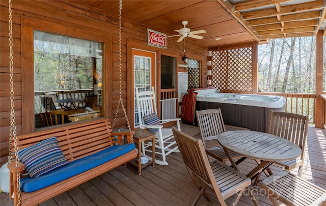 deck featuring a hot tub, ceiling fan, and outdoor dining space