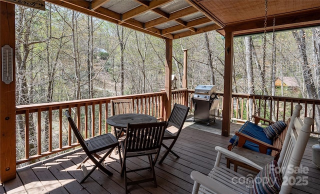 wooden deck featuring outdoor dining area and grilling area