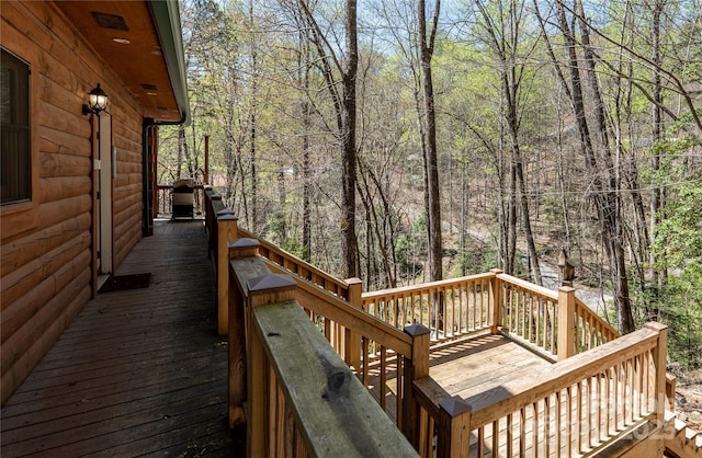wooden deck featuring a forest view and stairway