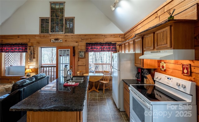kitchen featuring brown cabinets, a sink, exhaust hood, white appliances, and vaulted ceiling