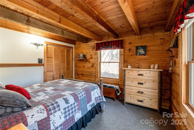 carpeted bedroom featuring a closet, beam ceiling, wood walls, and wood ceiling