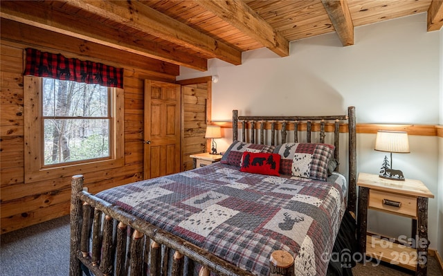 bedroom with wooden walls, carpet flooring, beamed ceiling, and wood ceiling