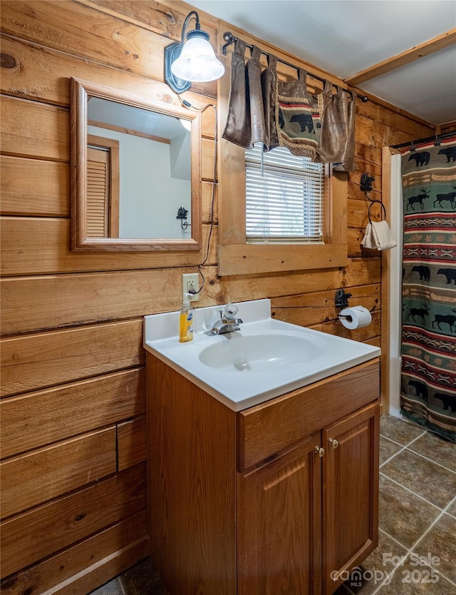 full bathroom featuring wooden walls, tile patterned floors, and vanity