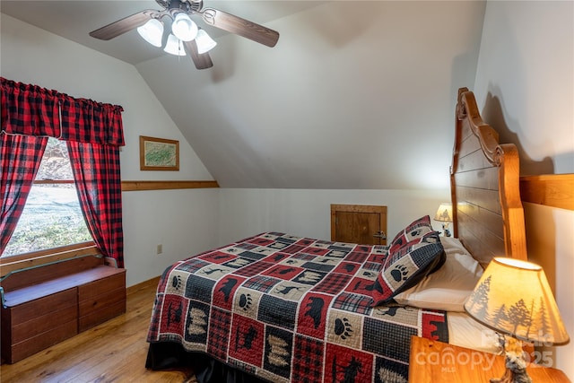 bedroom with lofted ceiling, hardwood / wood-style floors, and a ceiling fan