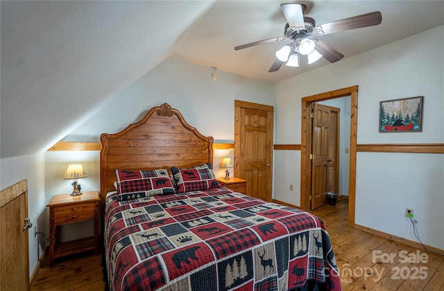 bedroom featuring vaulted ceiling, baseboards, ceiling fan, and hardwood / wood-style flooring
