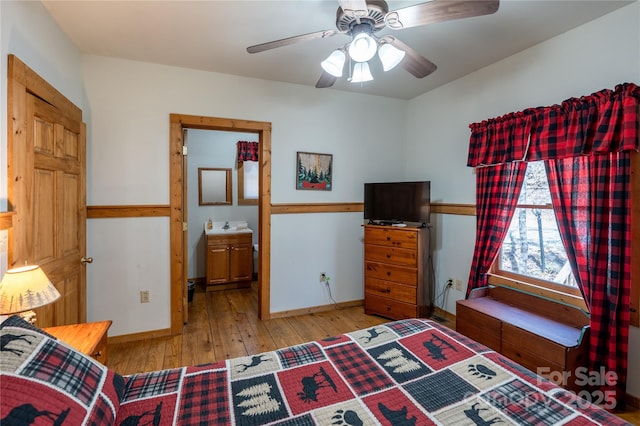 bedroom featuring a sink, ceiling fan, wood-type flooring, and baseboards