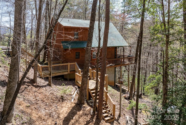 rear view of property featuring metal roof, stairs, and a wooden deck