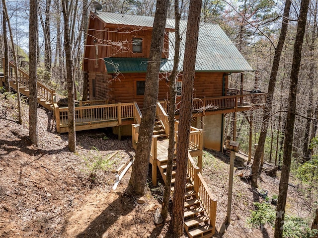exterior space featuring metal roof, stairway, and log siding