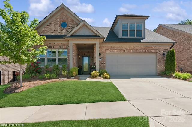 view of front of house featuring a garage, a front yard, roof with shingles, brick siding, and concrete driveway
