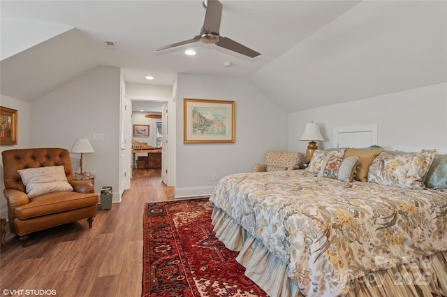 bedroom featuring ceiling fan, visible vents, wood finished floors, baseboards, and lofted ceiling