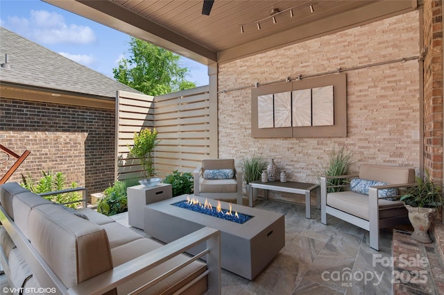 view of patio / terrace with an outdoor living space with a fire pit and ceiling fan