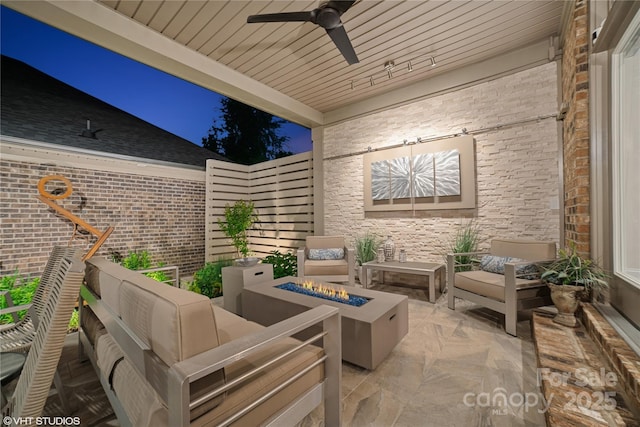 view of patio / terrace with an outdoor living space with a fire pit and ceiling fan