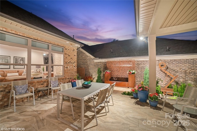 patio terrace at dusk featuring outdoor dining space