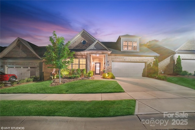 view of front facade featuring brick siding, an attached garage, driveway, and a front yard