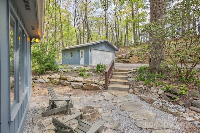 view of patio / terrace with a detached garage and an outbuilding