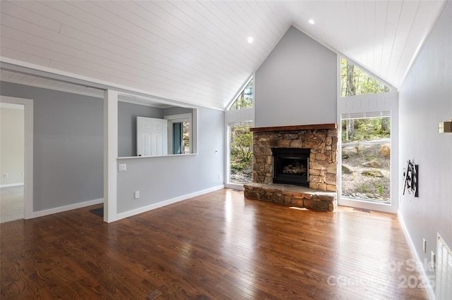 unfurnished living room with high vaulted ceiling, visible vents, a stone fireplace, and a wealth of natural light
