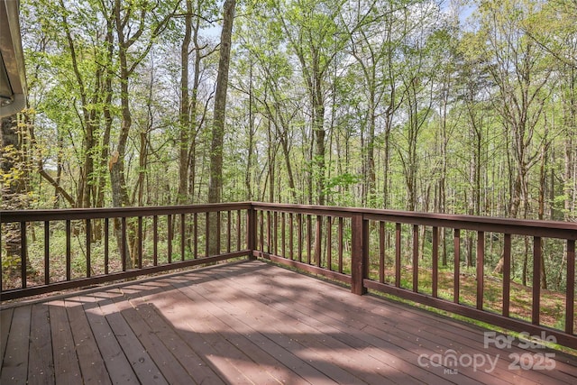 wooden terrace featuring a forest view