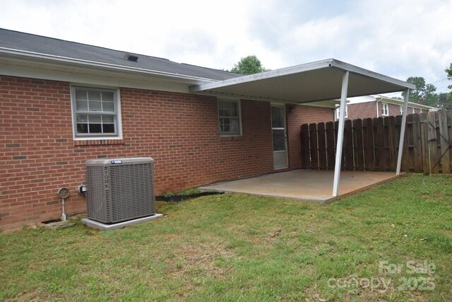 902 Church St NW, Valdese, NC 28690 - rear view of house featuring fence, central AC, brick siding, a lawn, and a patio
