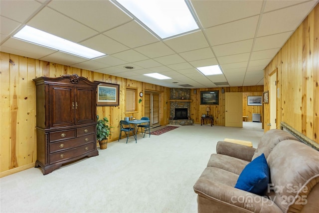 1053 Rich Hill Mountain Rd, Glade Valley, NC 28627 - living room featuring wooden walls, a stone fireplace, a drop ceiling, and light carpet